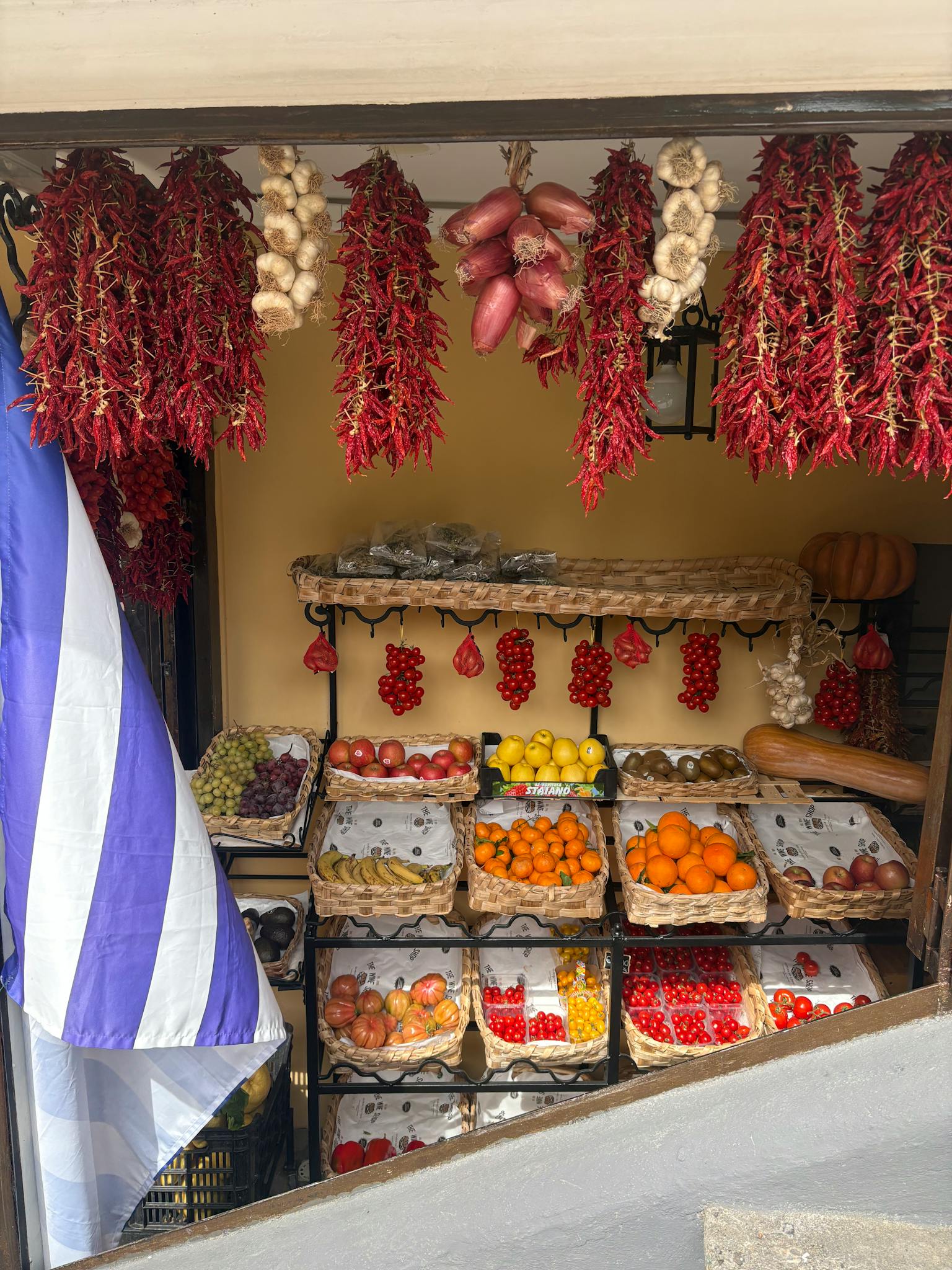 Colorful market stall in Positano displaying fruits, vegetables, and spices. Perfect for travel and lifestyle themes.